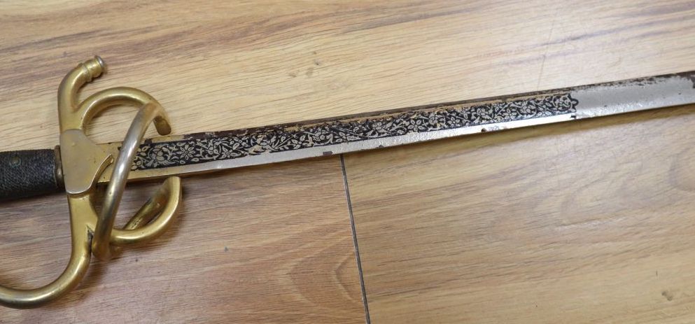 An officers sword with cast hilt and etched, 61cm double-edged blade